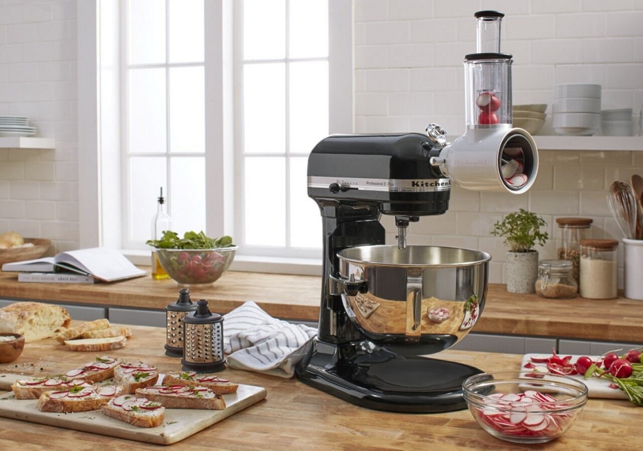 Black KitchenAid® stand mixer with fresh prep slicer/shredder attachment and vegetables inside