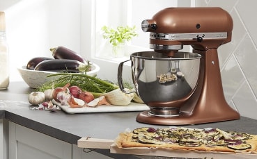 Copper KitchenAid® stand mixer next to vegetables on counter 