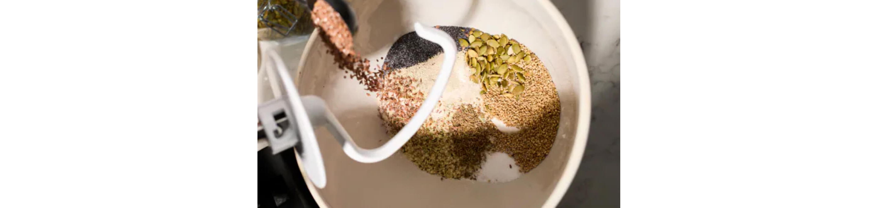 A variety of grains in the bowl of a stand mixer.