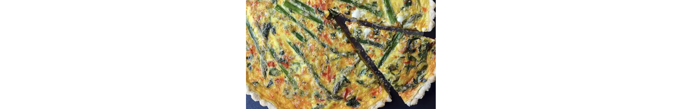 Asparagus red pepper quiche with one slice cut.