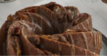 A prepared cake on a counter, drizzled with icing.