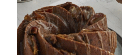 A prepared cake on a counter, drizzled with icing.