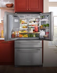 A large KitchenAid® refrigerator fully stocked with fresh ingredients and packaged food items