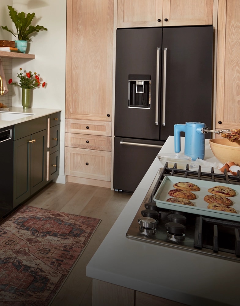 A side-by-side KitchenAid® refrigerator installed between light wood cabinets
