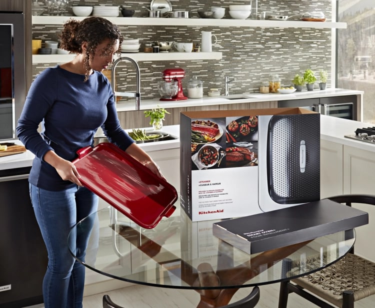 A kitchen with green cabinets and stainless steel KitchenAid® appliances