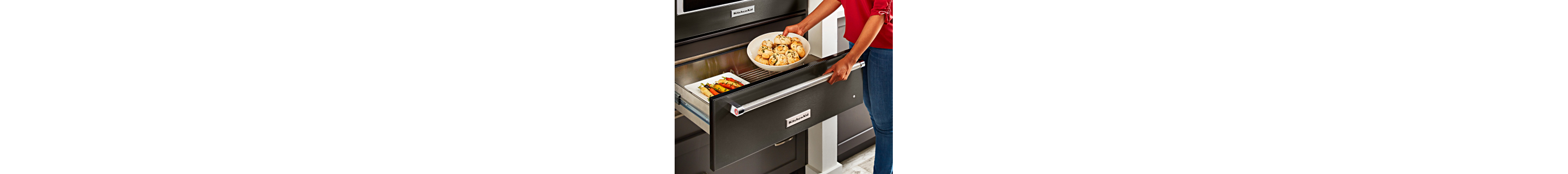 Person placing food in warming drawer