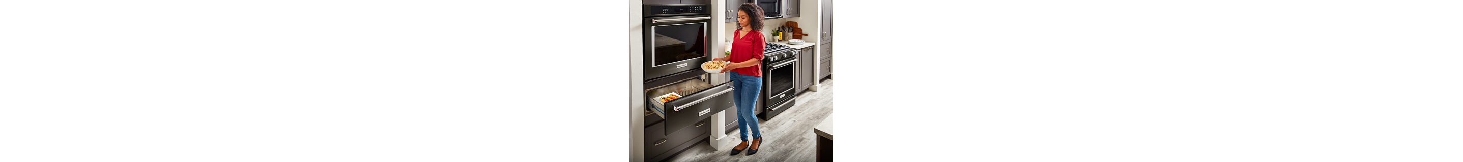 Person placing dishes in warming drawer