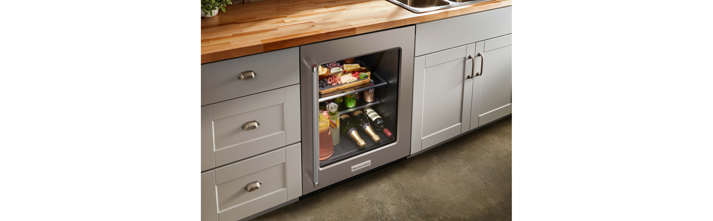 A KitchenAid® undercounter refrigerator among grey cabinets 