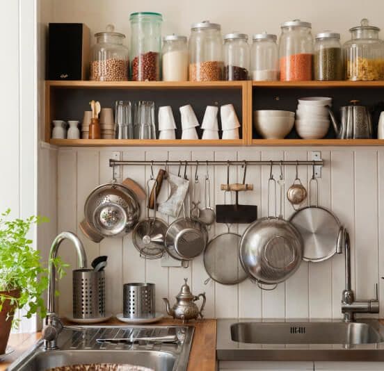 A kitchen filled with utensils, spices, dinnerware and more.