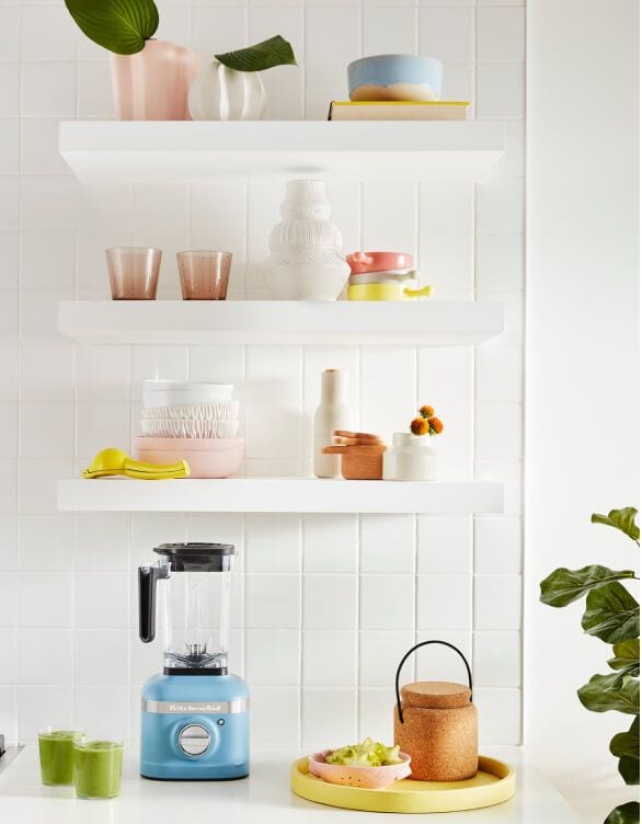 Clean white shelves adorned glasses, bowls and other kitchen utensils.