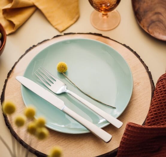 A set table with wooden and floral accents.