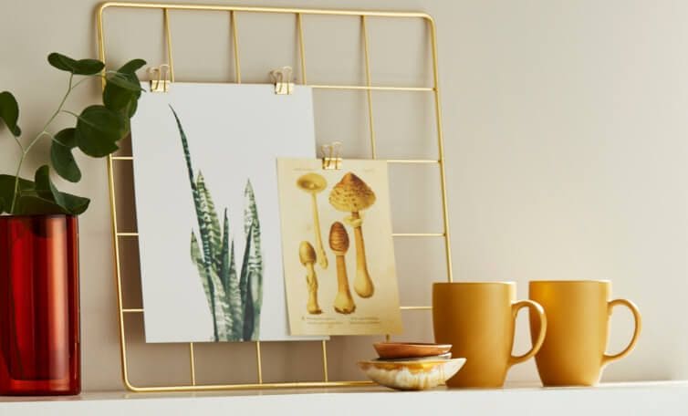 A table adorned with plants, art and other decor.