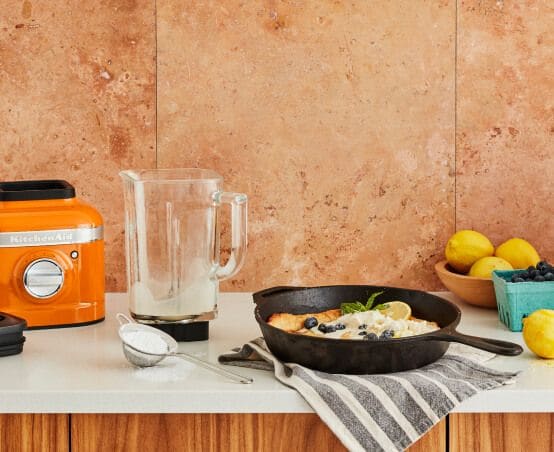 A K400 Variable Speed Blender in Honey next to a loaded cast iron skillet.