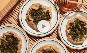 Brie veggie tarts resting on small, delicate plates.