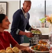 People passing dishes at a dinner party.