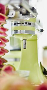 A close-up of a Kyoto Glow Stand Mixer spiralizing a watermelon radish.