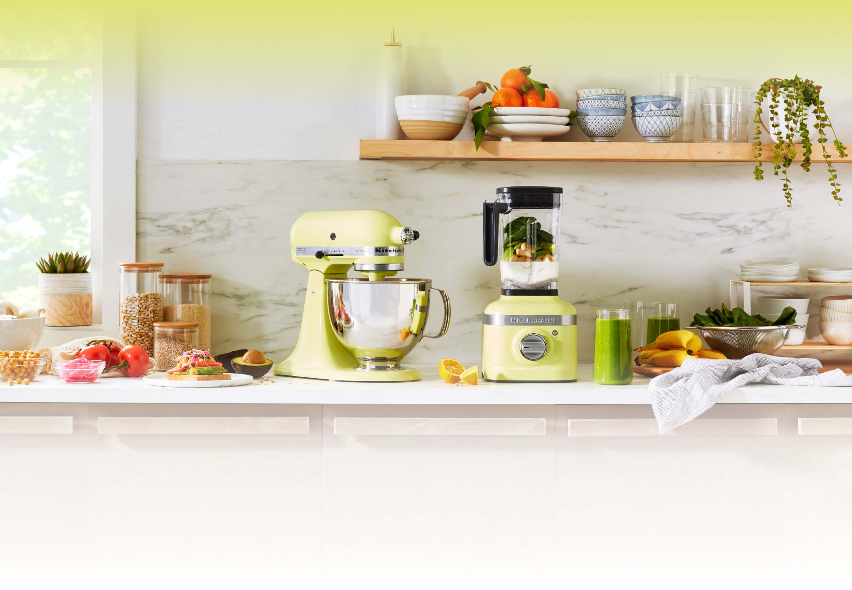 A bright counter with a Kyoto Glow KitchenAid® Artisan® Series Stand Mixer and K400 Variable Blender.