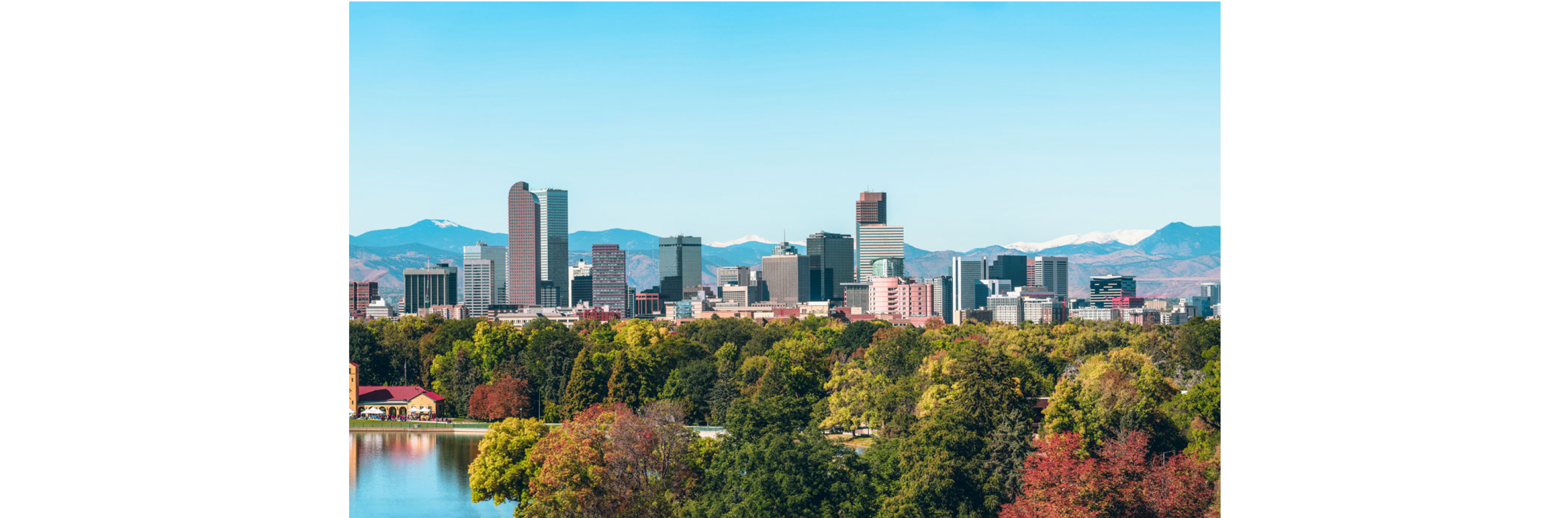 The city of Denver surrounded by picturesque mountains and colorful trees.