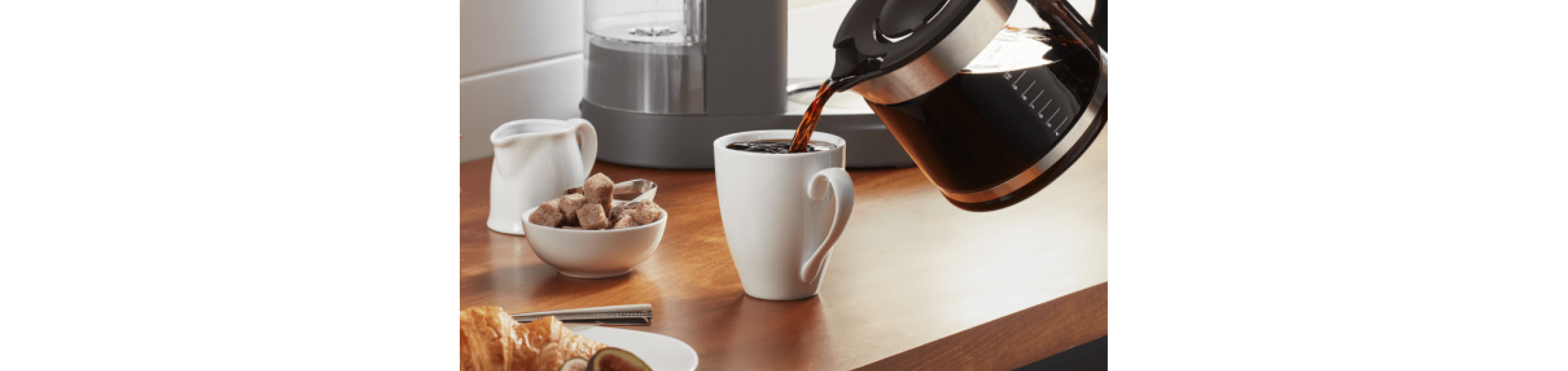 Coffee being poured into white coffee cup.