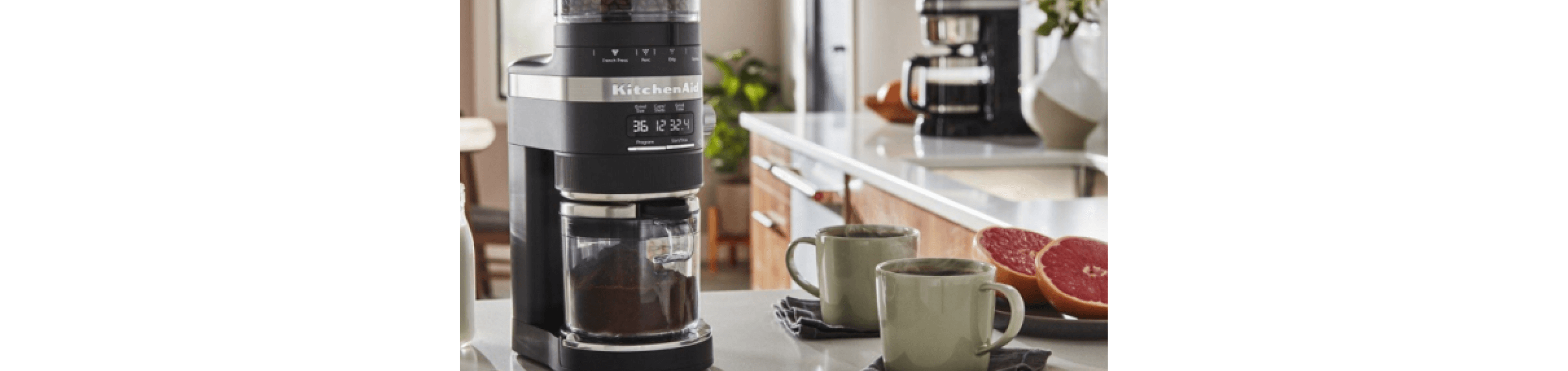 Best home coffee setup on countertop, including KitchenAid® Burr Grinder surrounded by milk, cinnamon, two cups of coffee and grapefruit.