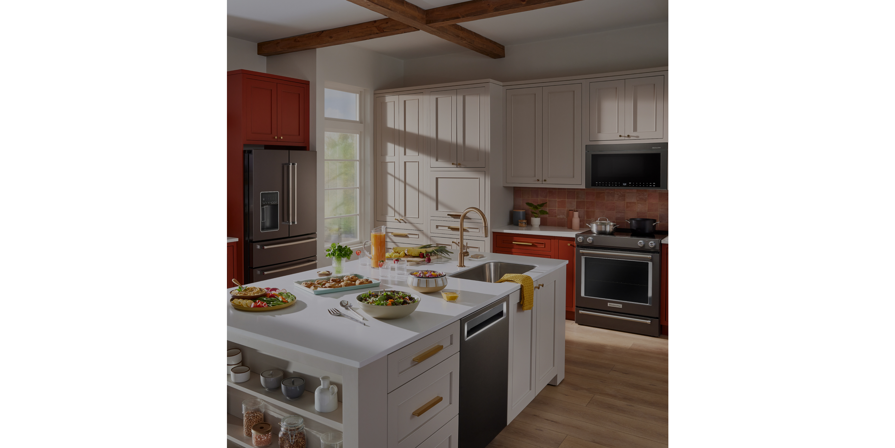A kitchen with red and white cabinets and various KitchenAid® appliances.