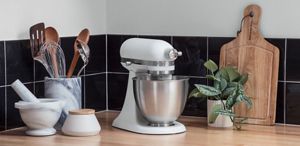 An Artisan® Mini Tilt-Head resting on a wooden countertop.