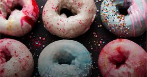 KitchenAid® Artisan® Series Stand Mixer shown against a background of colorful doughnuts.