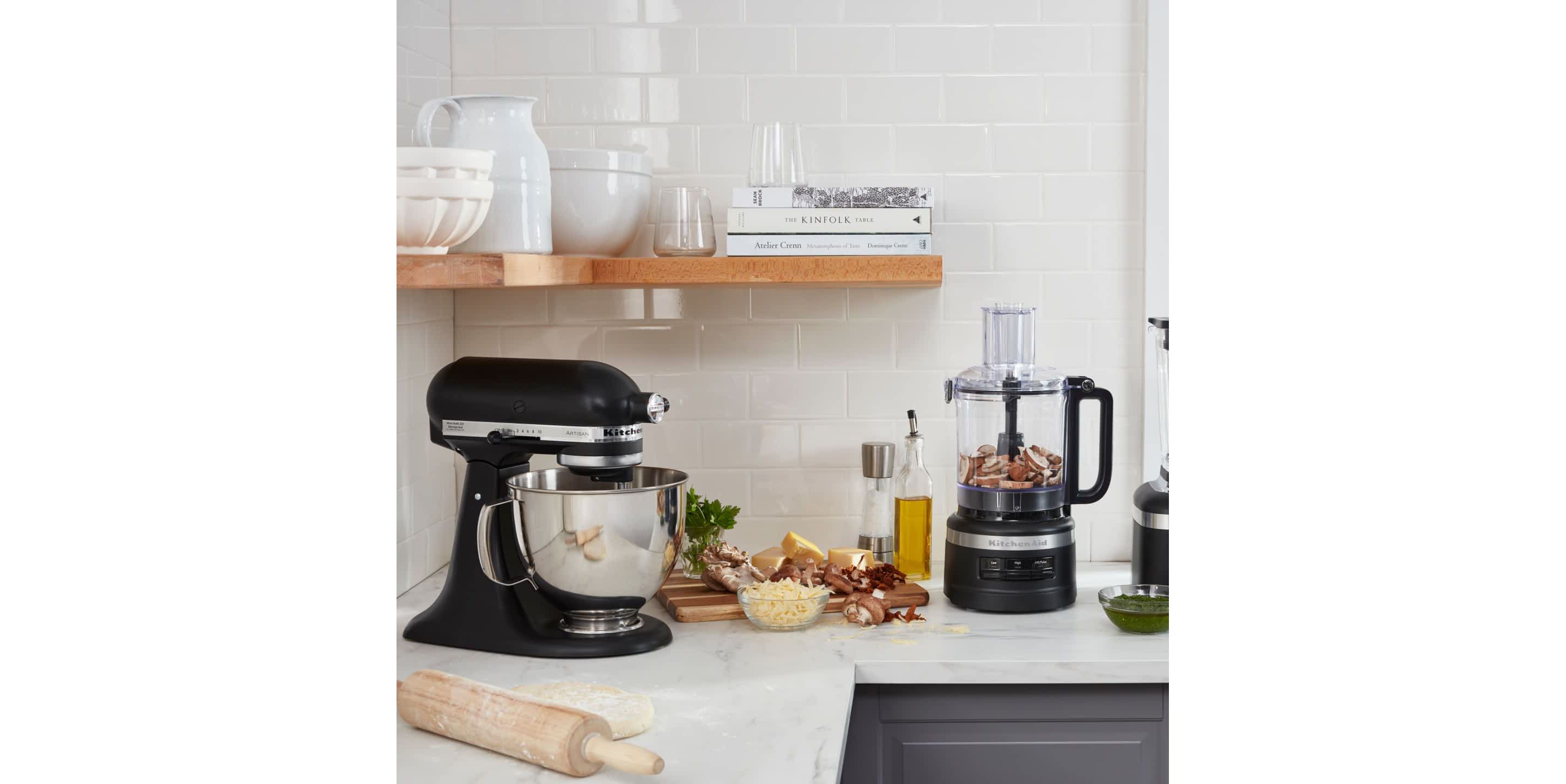 A KitchenAid® Stand Mixer and Food Processor in a crisp, stylish kitchen preparing fresh ingredients. 