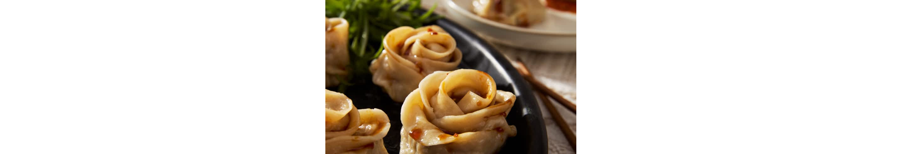 Rose-shaped gyoza dumplings on a plate. 
