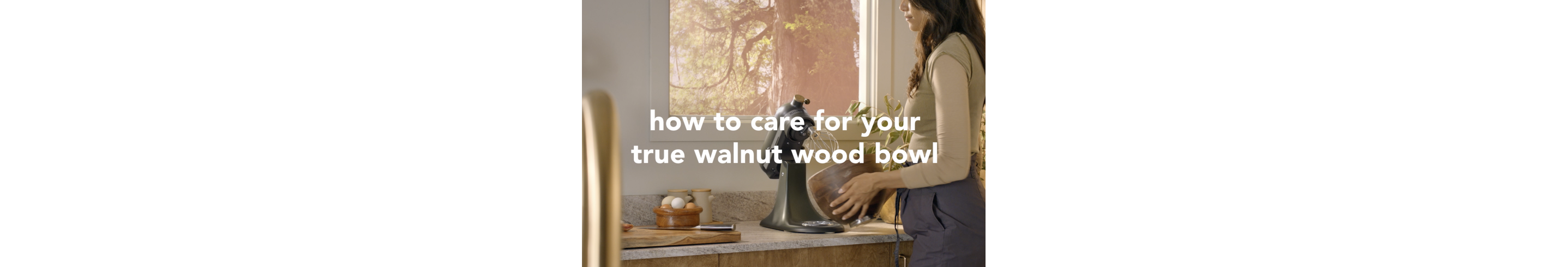 A person holding the true walnut bowl of the Evergreen stand mixer