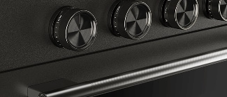 A close-up on the handle and knobs of a Black Ore range.