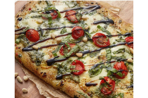A sliced, freshly made pizza resting on a wooden cutting board.