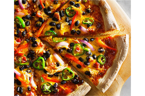 A sliced, freshly made pizza resting on a wooden cutting board.
