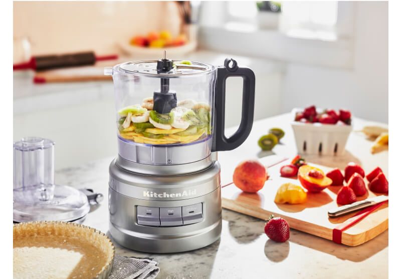 A Contour Silver 7 Cup Food Processor chopping assorted fruits.