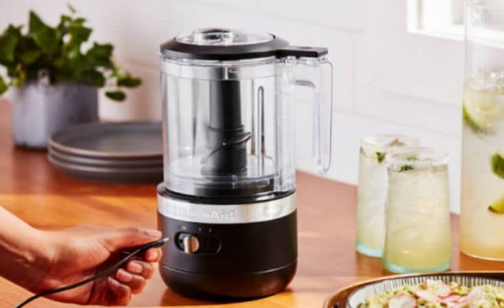 A person plugging in the KitchenAid® Cordless Hand Chopper.