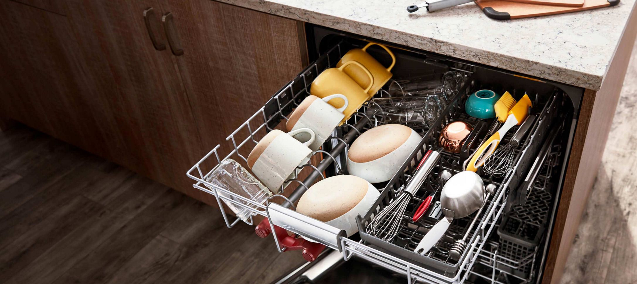 A fully loaded FreeFlex™ Third Rack Dishwasher installed under a bright kitchen counter.