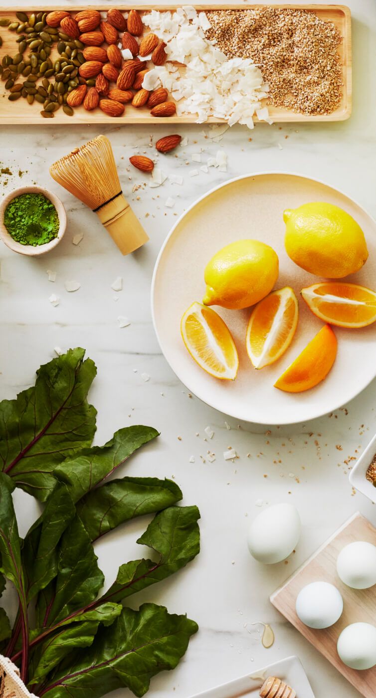 Lemons, rhubarb, matcha powder and other assorted ingredients resting on a bright countertop.