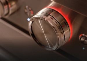 Close-up of temperature dial on a stainless steel range.