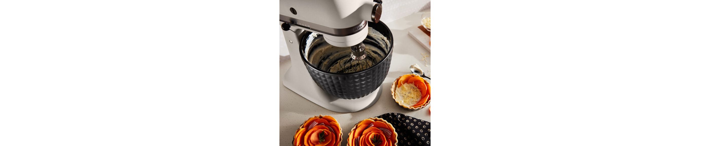 A Limited Edition Stand Mixer with Black Ceramic Studded Bowl whipping cream.
