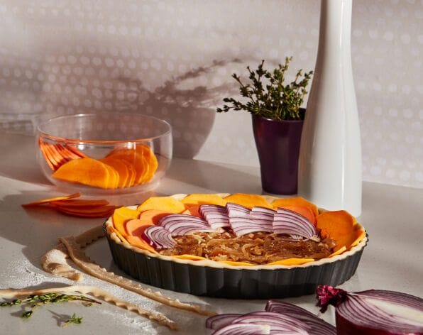 A small platter with sliced vegetables placed in a floral pattern.