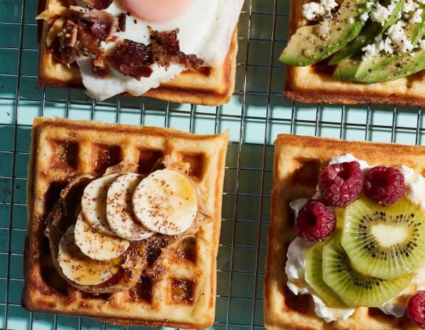 Waffles with an assortment of toppings placed on a cooling rack.