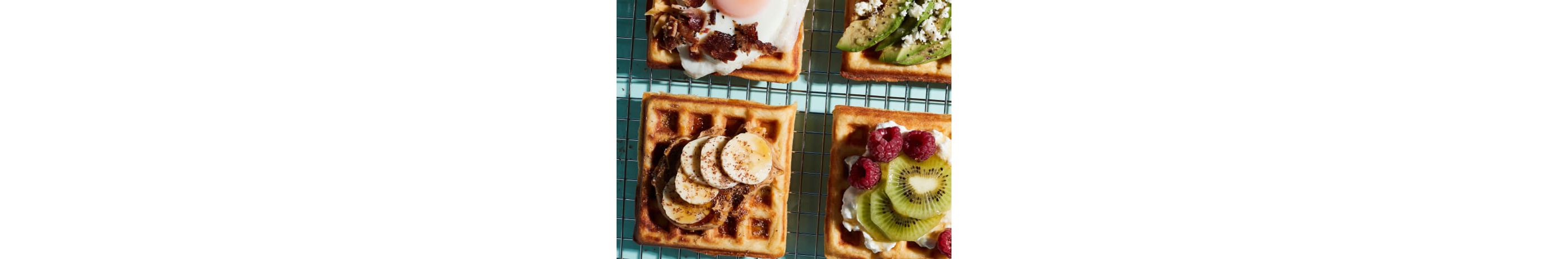 Waffles with an assortment of toppings placed on a cooling rack.