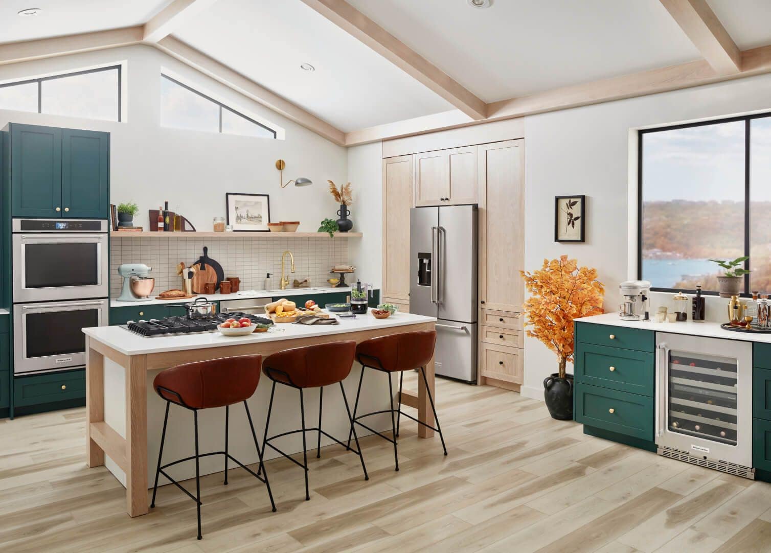 A bright, stylish kitchen featuring teal cabinetry and various KitchenAid® appliances.