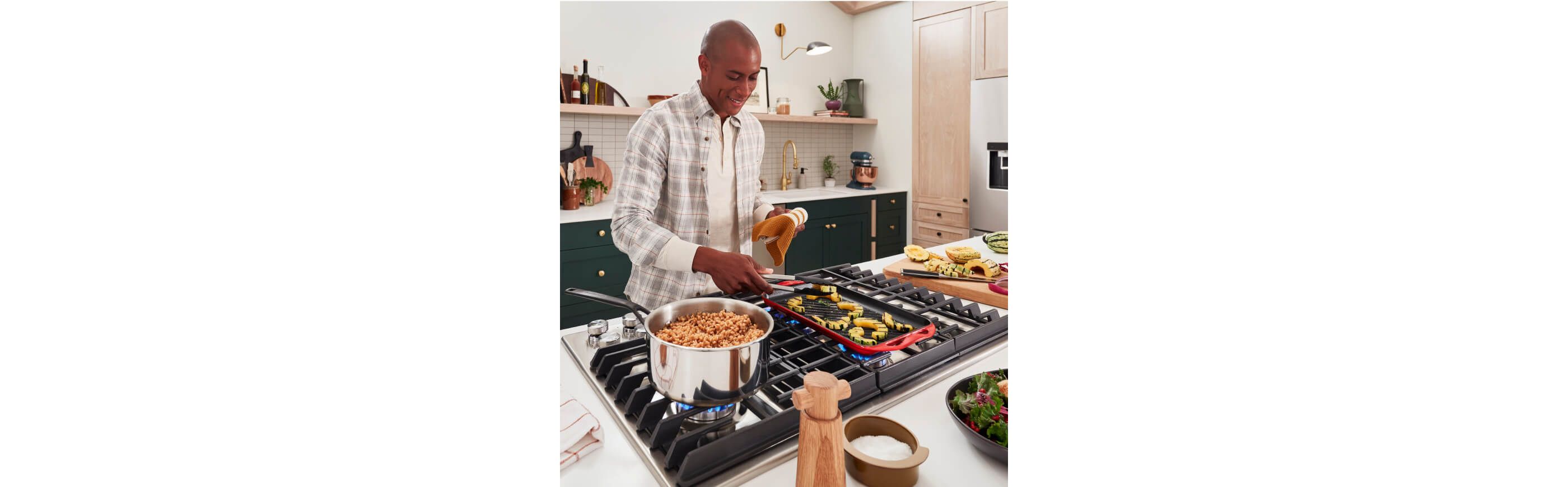 A person cooking on a cooktop, with different ingredients across the countertop.