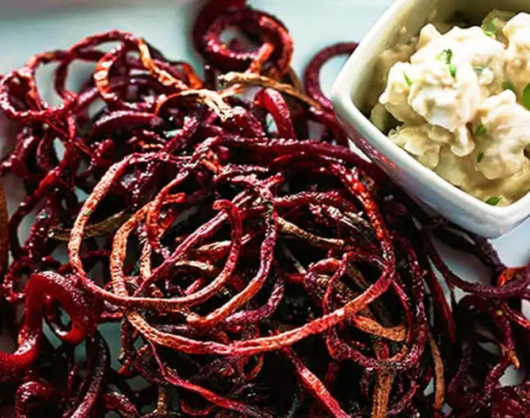 Roasted beet strings served on a plate with a balsamic goat cheese dip.