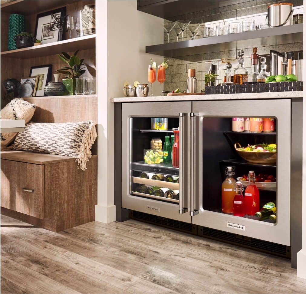 Two fully stocked KitchenAid® undercounter refrigerators installed in a wet bar.