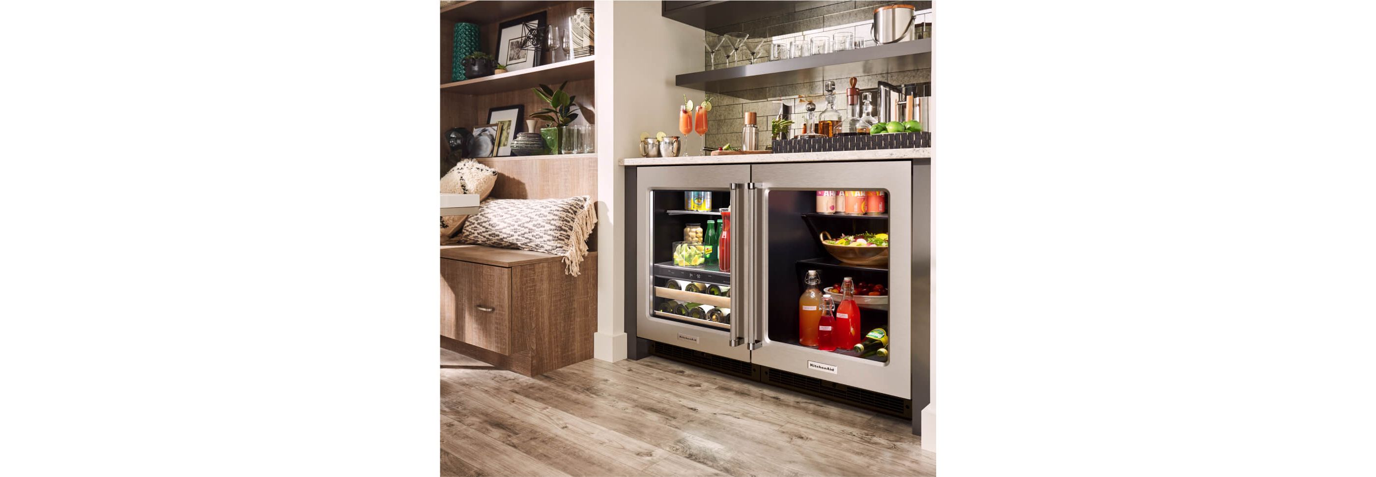 Two fully stocked KitchenAid® undercounter refrigerators installed in a wet bar.