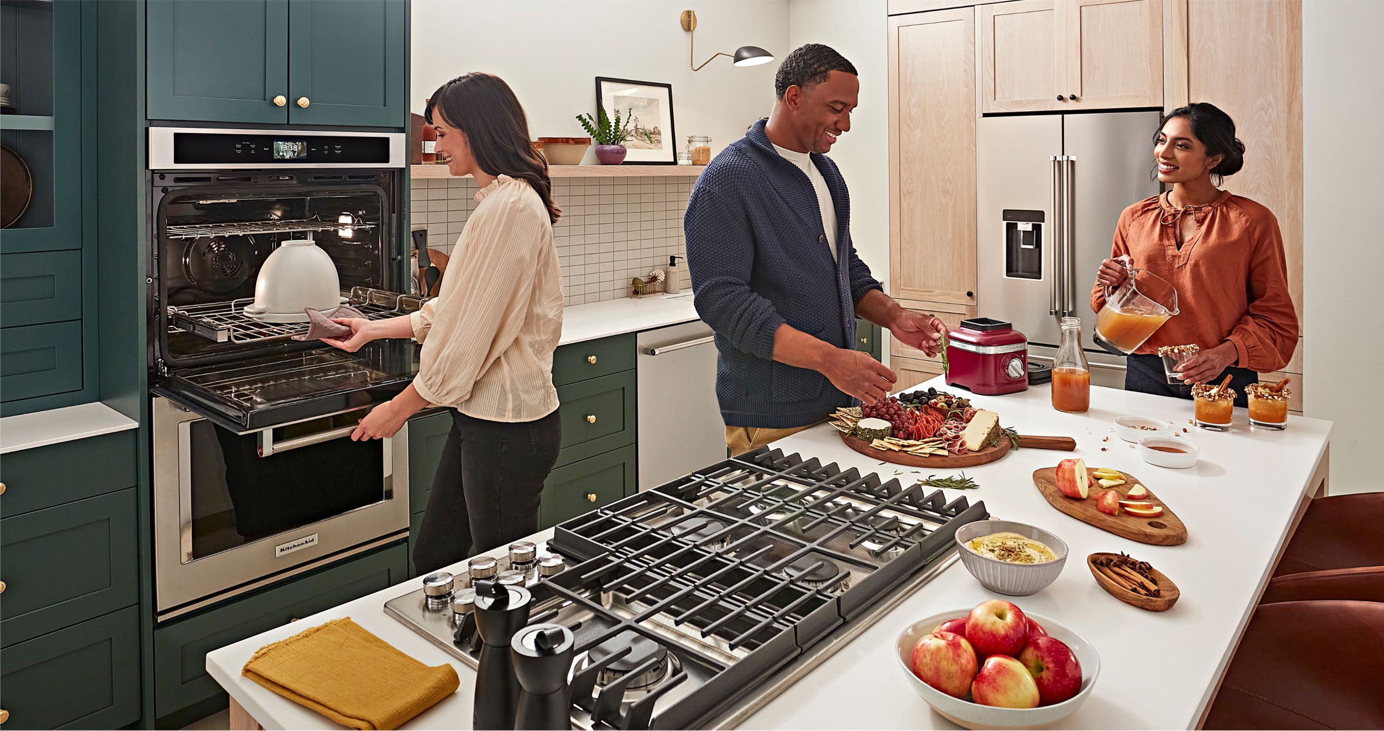 A group of people cooking different ingredients in a modern, stylish kitchen.