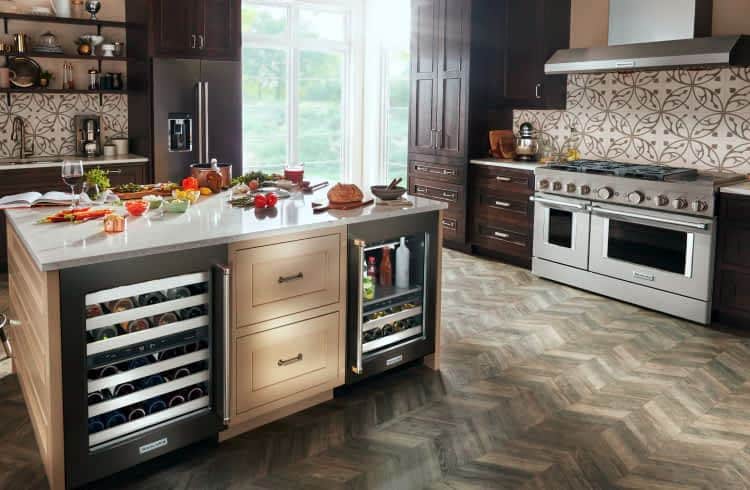 A rich, modern kitchen filled with KitchenAid® appliances and an island with different ingredients across the countertop.