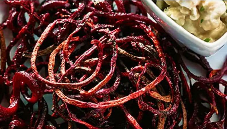 Roasted beet strings with balsamic goat cheese dip on a plate.
